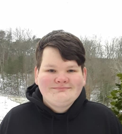 A young person outdoors in a wintery landscape.