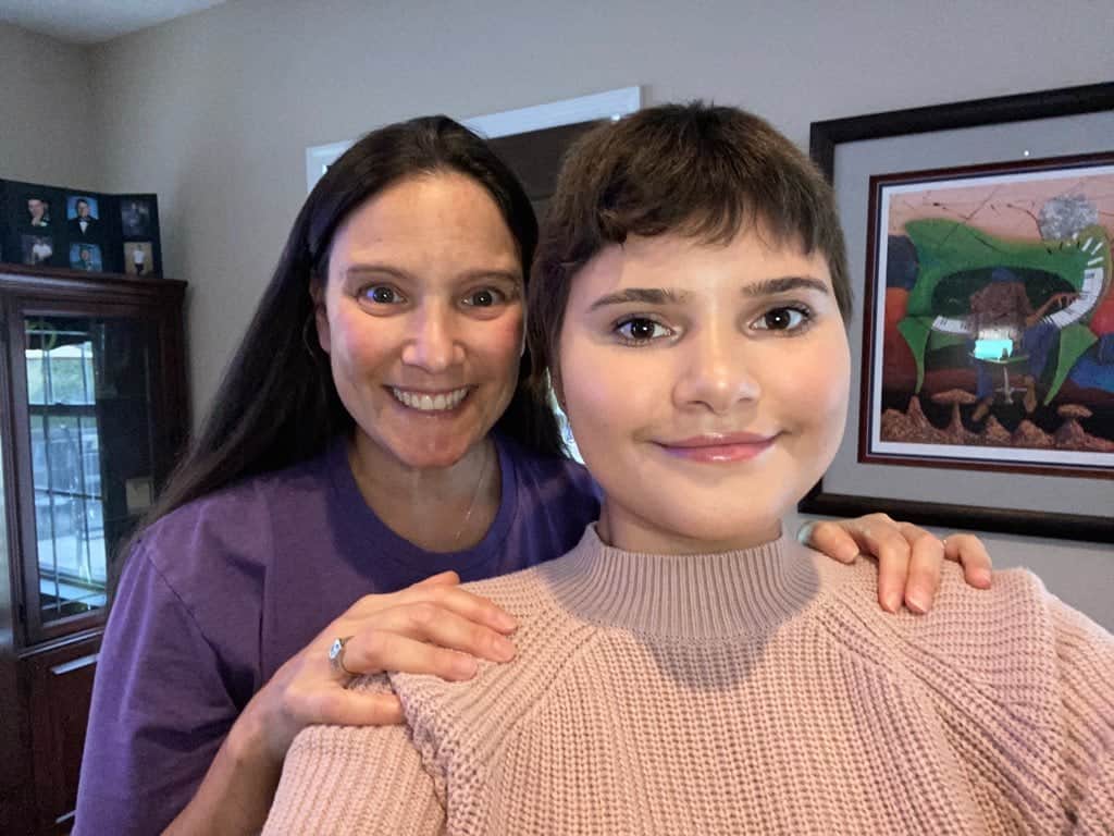 A smiling woman and child posing for a photo indoors.