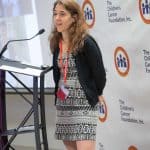 A woman speaking at a podium during a formal event.