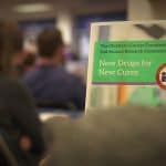 Person reading a book titled 'New Dream for New Life' in a public setting.