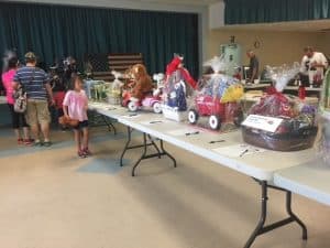 Children exploring a display of decorated wagons indoors.