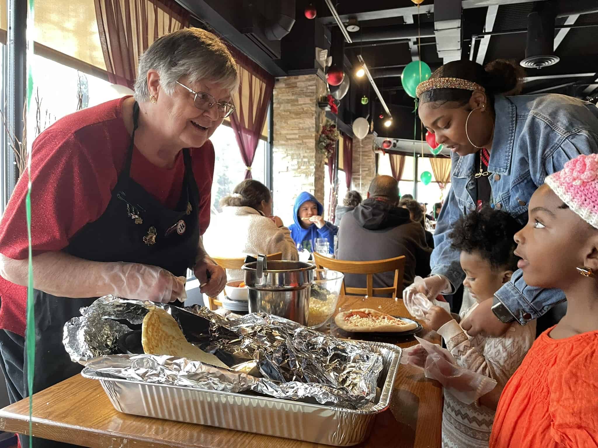 Family enjoying a meal with roasted corn at a lively restaurant.